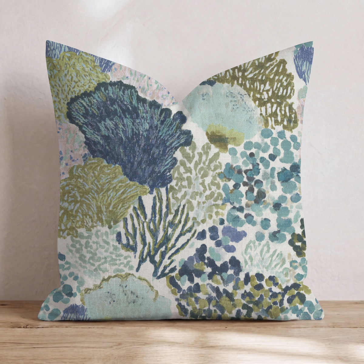 Blue abstract patterned throw pillow with coral-inspired design and piped edges