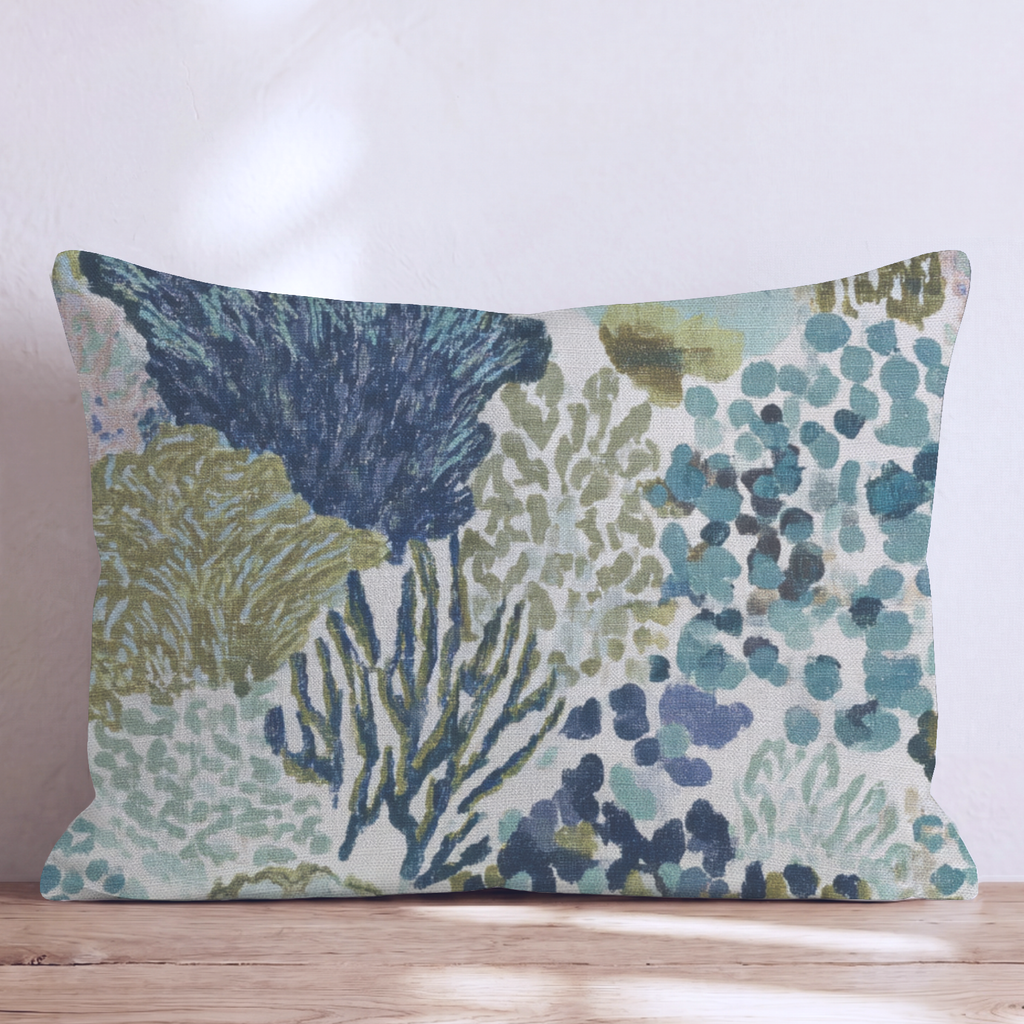Blue abstract patterned throw pillow with coral-inspired design and piped edges