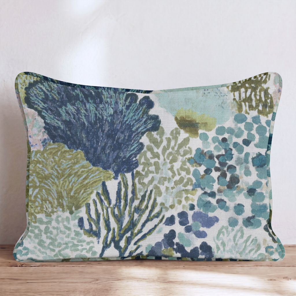 Blue abstract patterned throw pillow with coral-inspired design and piped edges