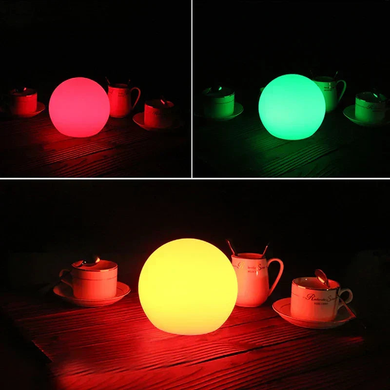 White spherical wireless LED table lamp glowing on a shelf