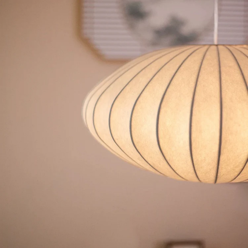 White oval ribbed pendant ceiling light suspended by a white cord