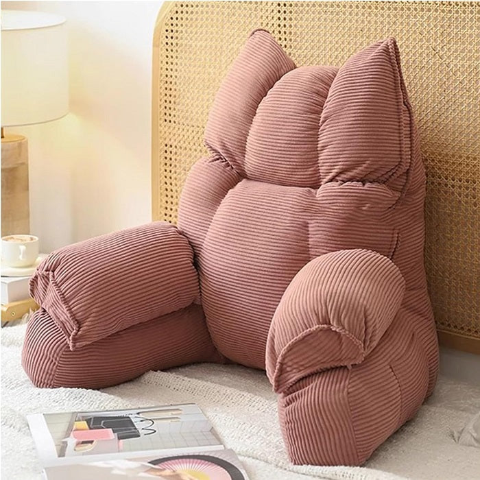 Cushioned bed reading pillow with raised arm supports and ribbed cover