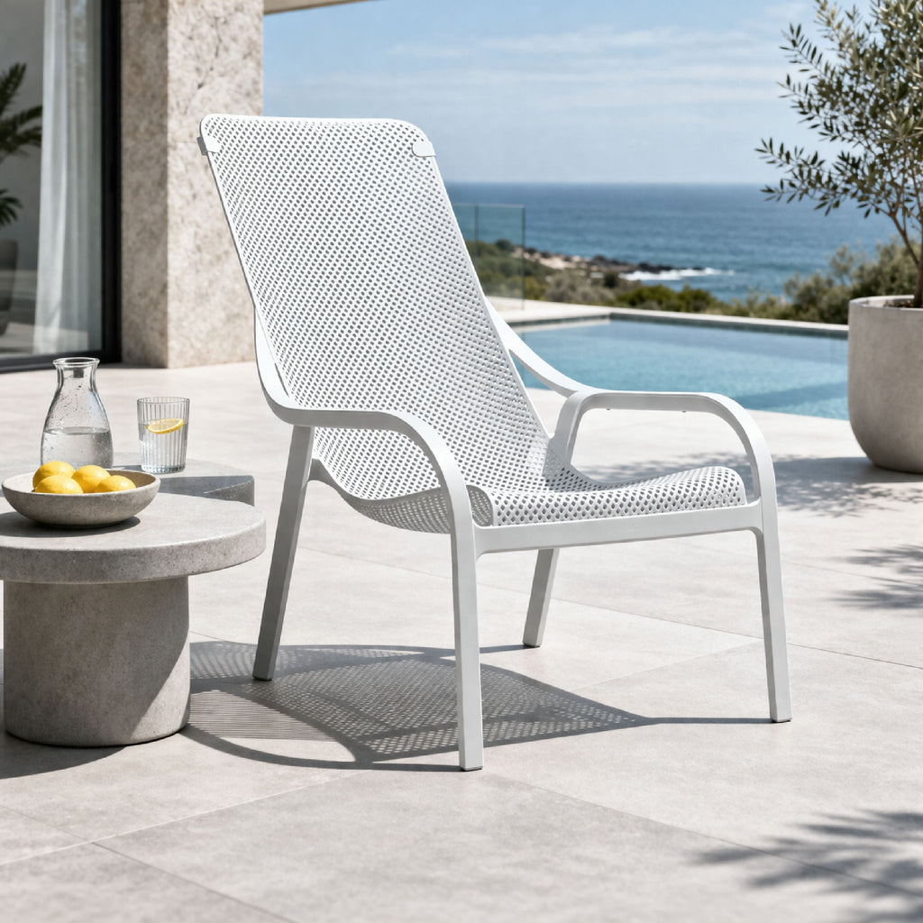 Perforated outdoor lounge chair with integrated arms and four legs