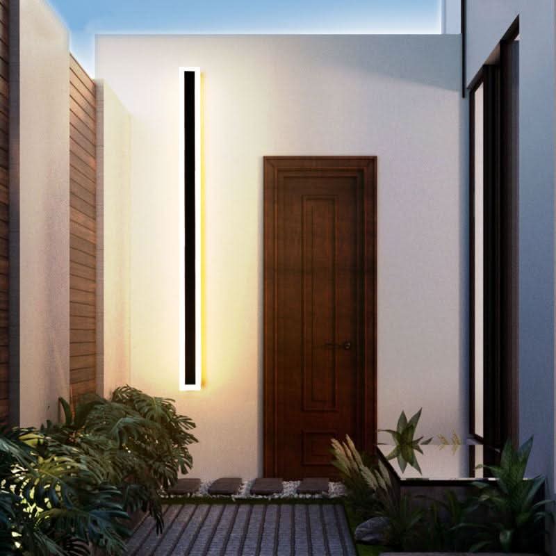 Slim black vertical outdoor wall light casting a warm glow
