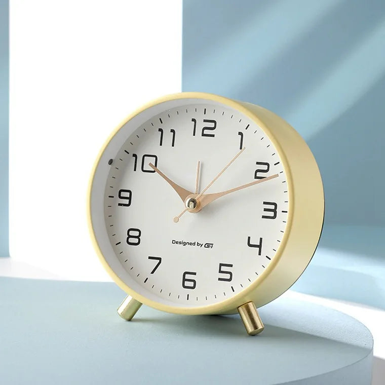 Round Scandinavian analogue table clock with numbered dial and twin feet