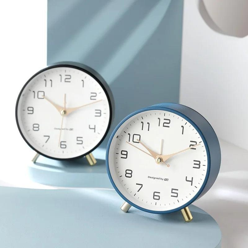 Round Scandinavian analogue table clock with numbered dial and twin feet