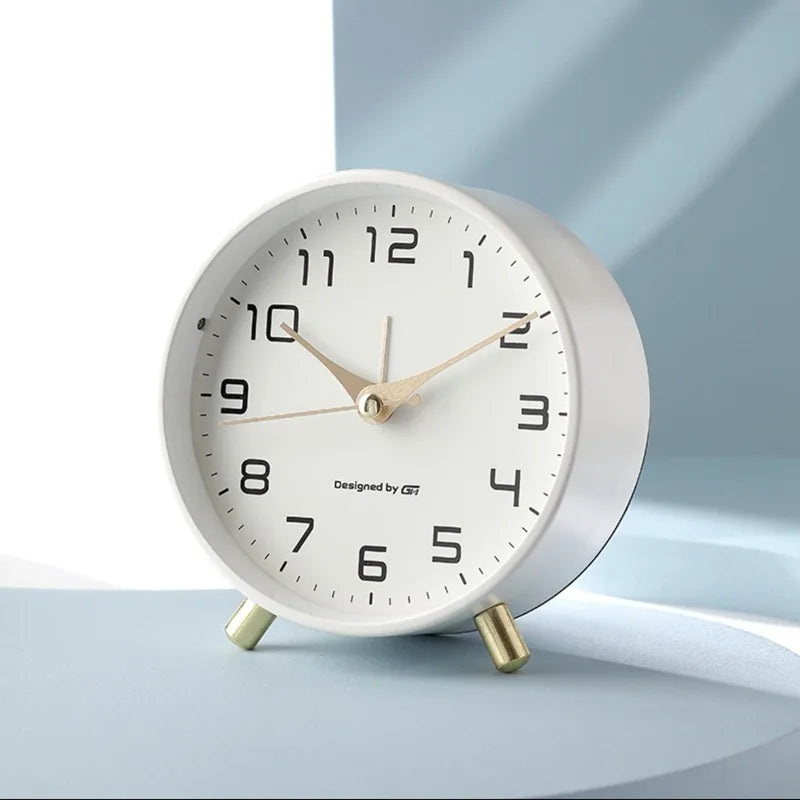 Round Scandinavian analogue table clock with numbered dial and twin feet