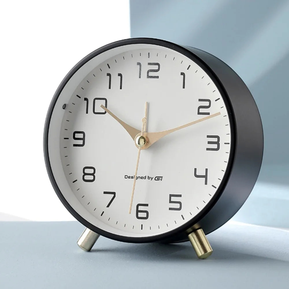 Round Scandinavian analogue table clock with numbered dial and twin feet