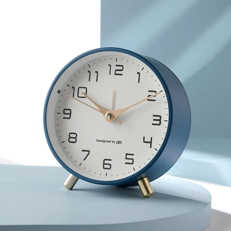 Round Scandinavian analogue table clock with numbered dial and twin feet