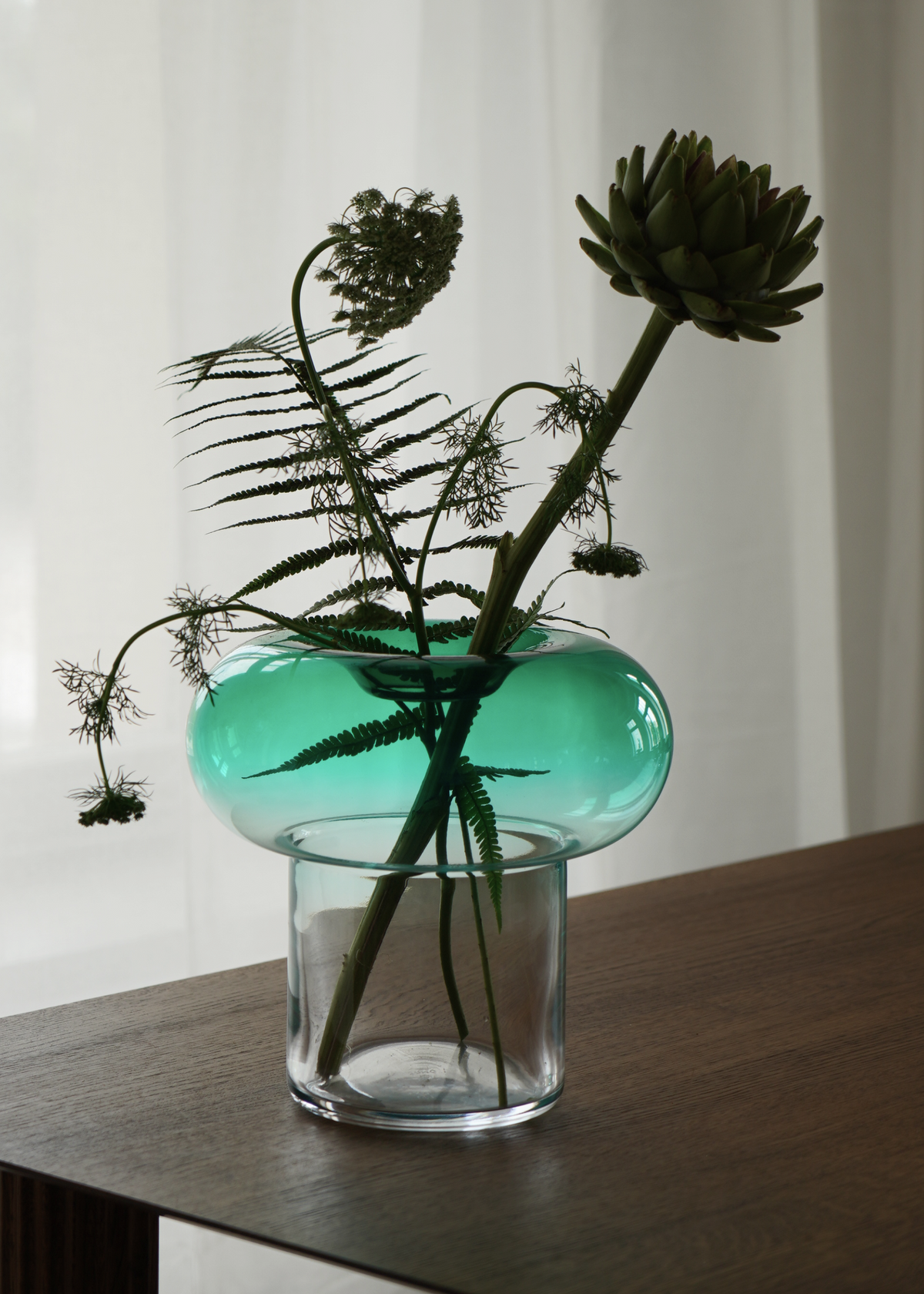 Green rounded glass vase with a clear base