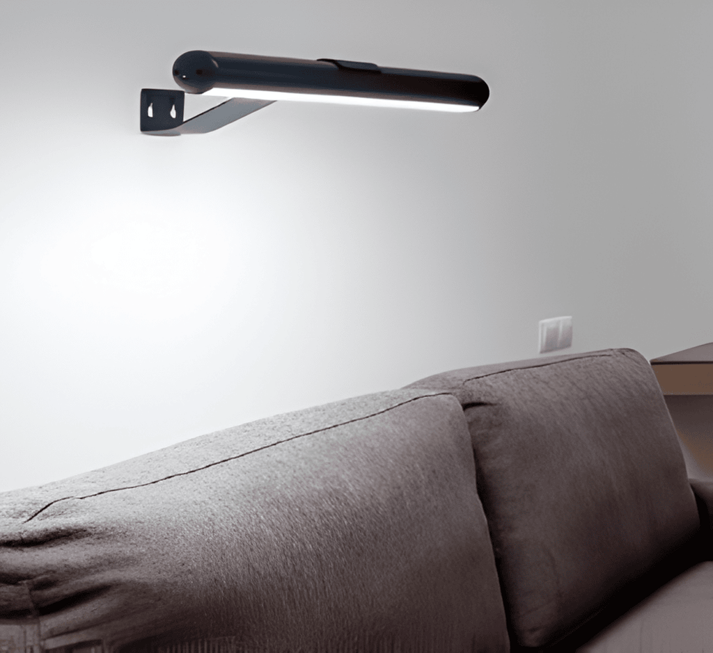 Cordless rotatable LED wall light mounted above framed artwork