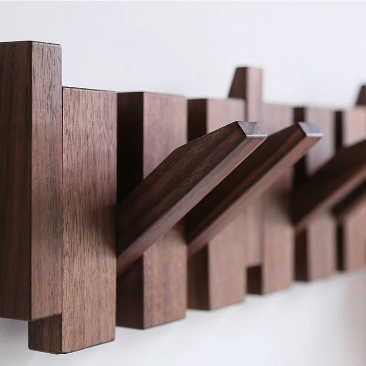 Wooden wall-mounted coat rack with multiple angled hooks