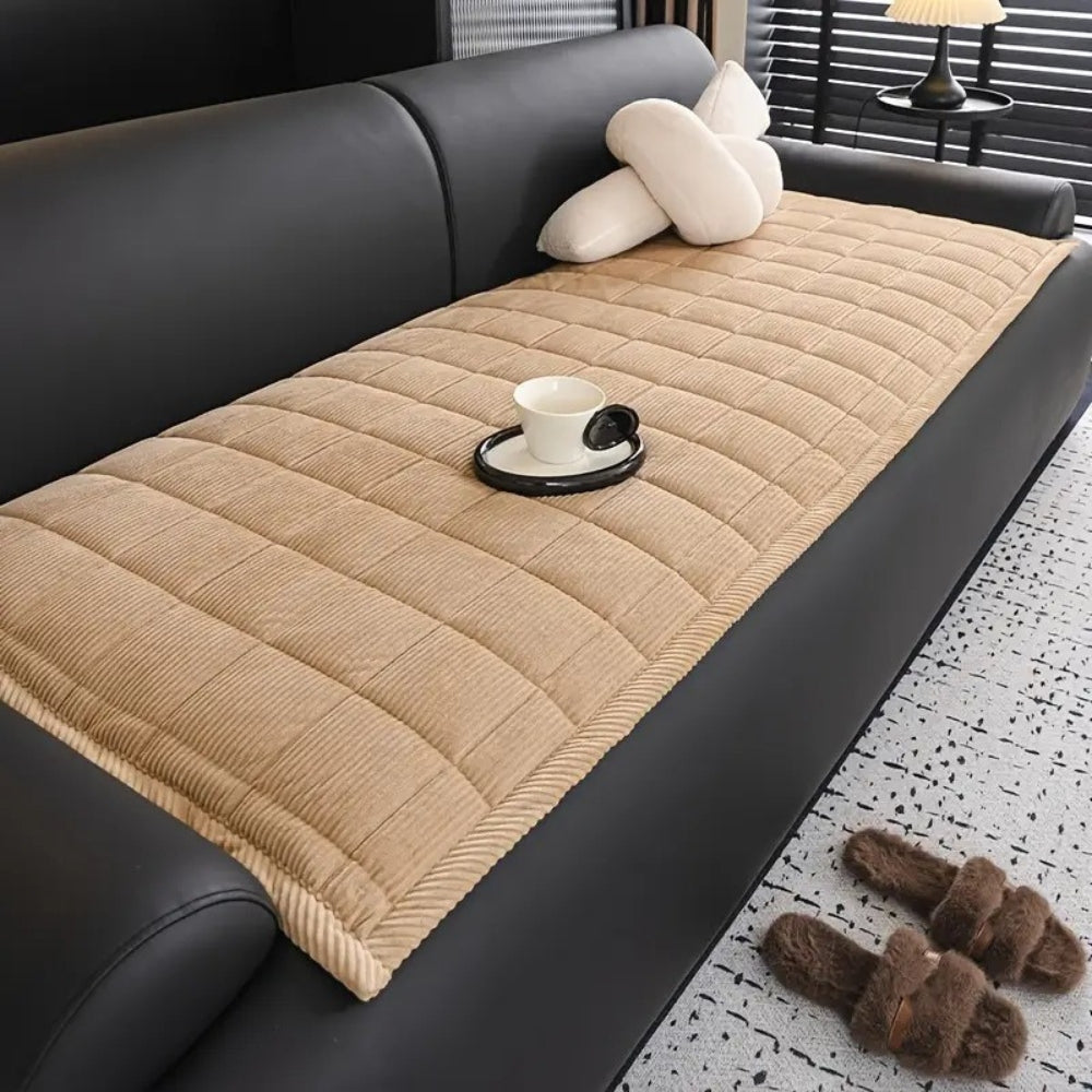 Quilted ribbed sofa cover mat laid across couch seating
