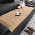 Quilted ribbed sofa cover mat laid across couch seating