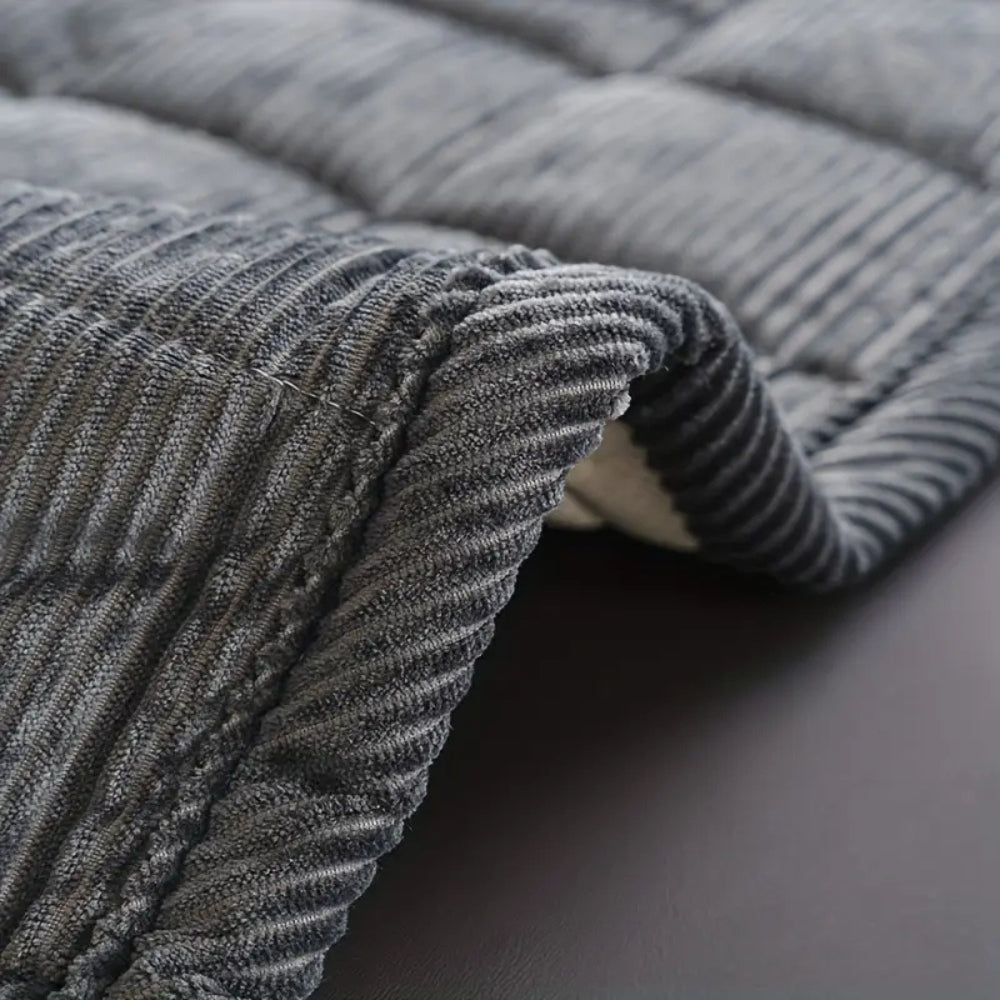Quilted ribbed sofa cover mat laid across couch seating