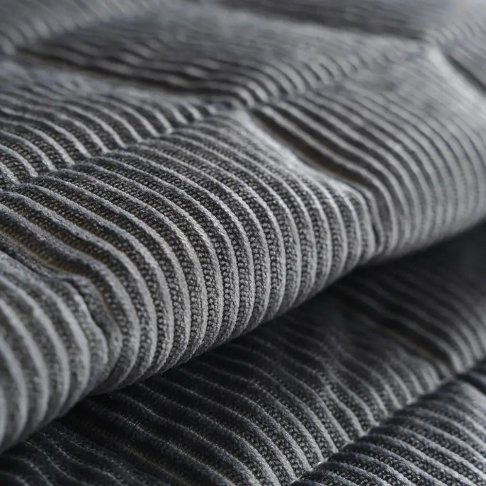 Quilted ribbed sofa cover mat laid across couch seating