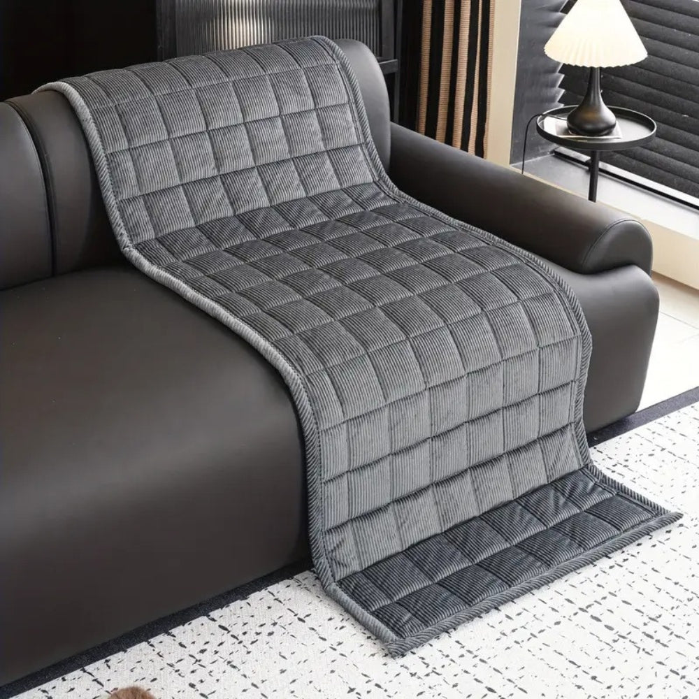 Quilted ribbed sofa cover mat laid across couch seating