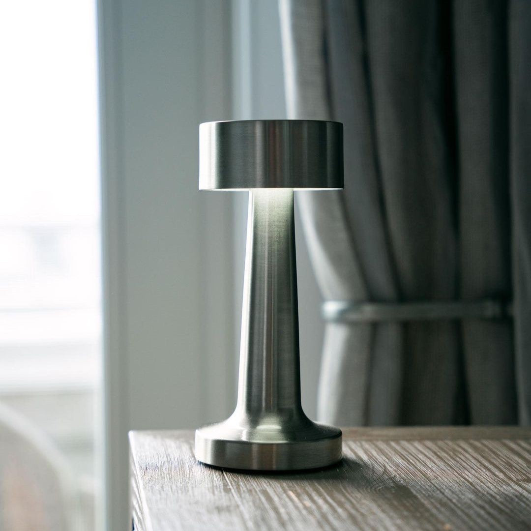 Table lamp with cylindrical shade, slim stem and round base