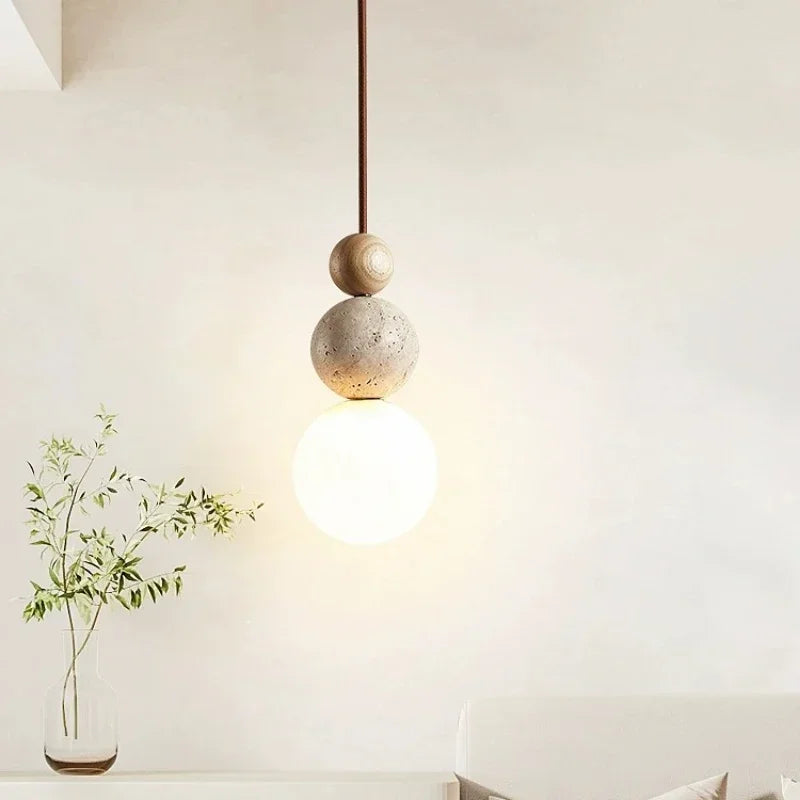 Pendant ceiling light with three stacked spherical details and a hanging cord