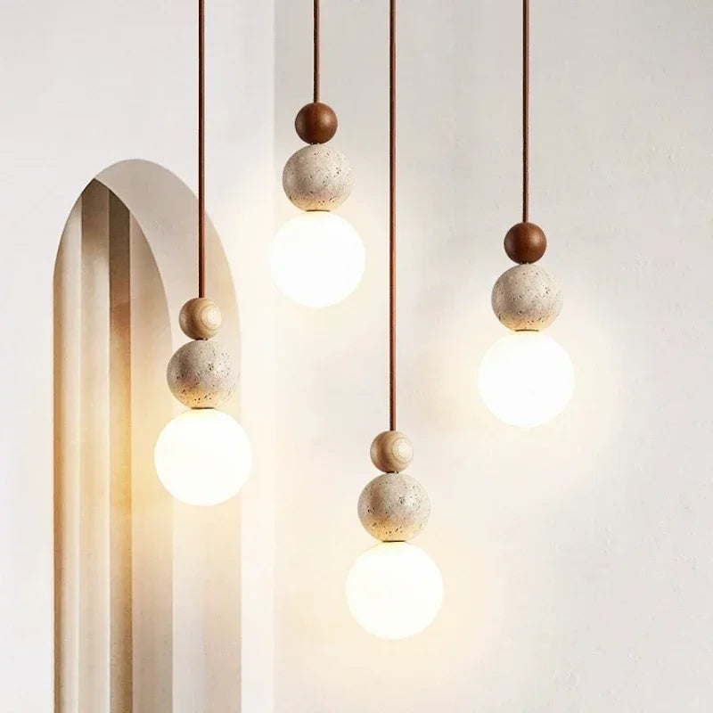 Pendant ceiling light with three stacked spherical details and a hanging cord