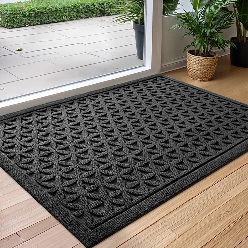 Rectangular geometric door mat with raised grooves by a glass entrance door