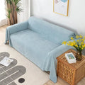 Solid light blue waterproof sofa cover draped over a sofa