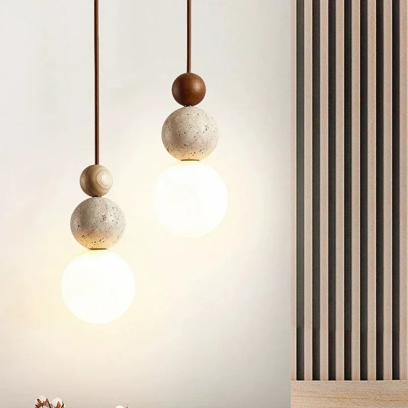 Pendant ceiling light with three stacked spherical details and a hanging cord