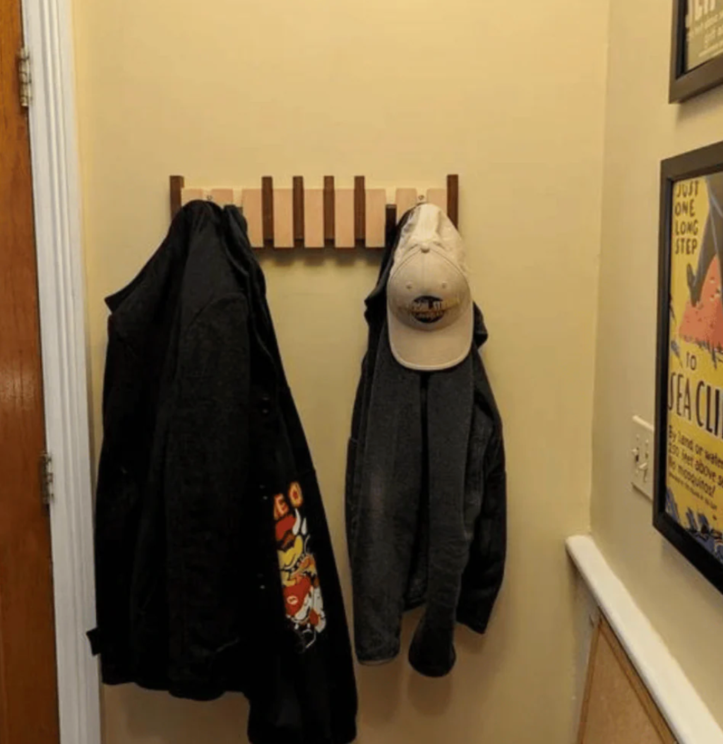 Wooden wall-mounted coat rack with multiple angled hooks