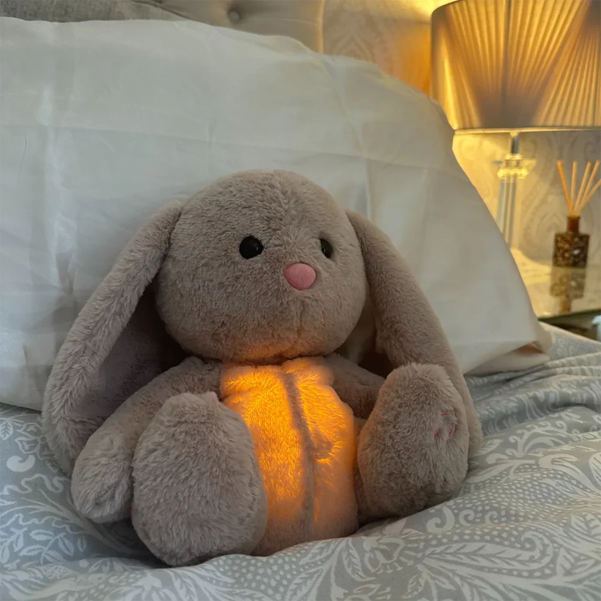 Grey rabbit stuffed animal with floppy ears and illuminated yellow belly