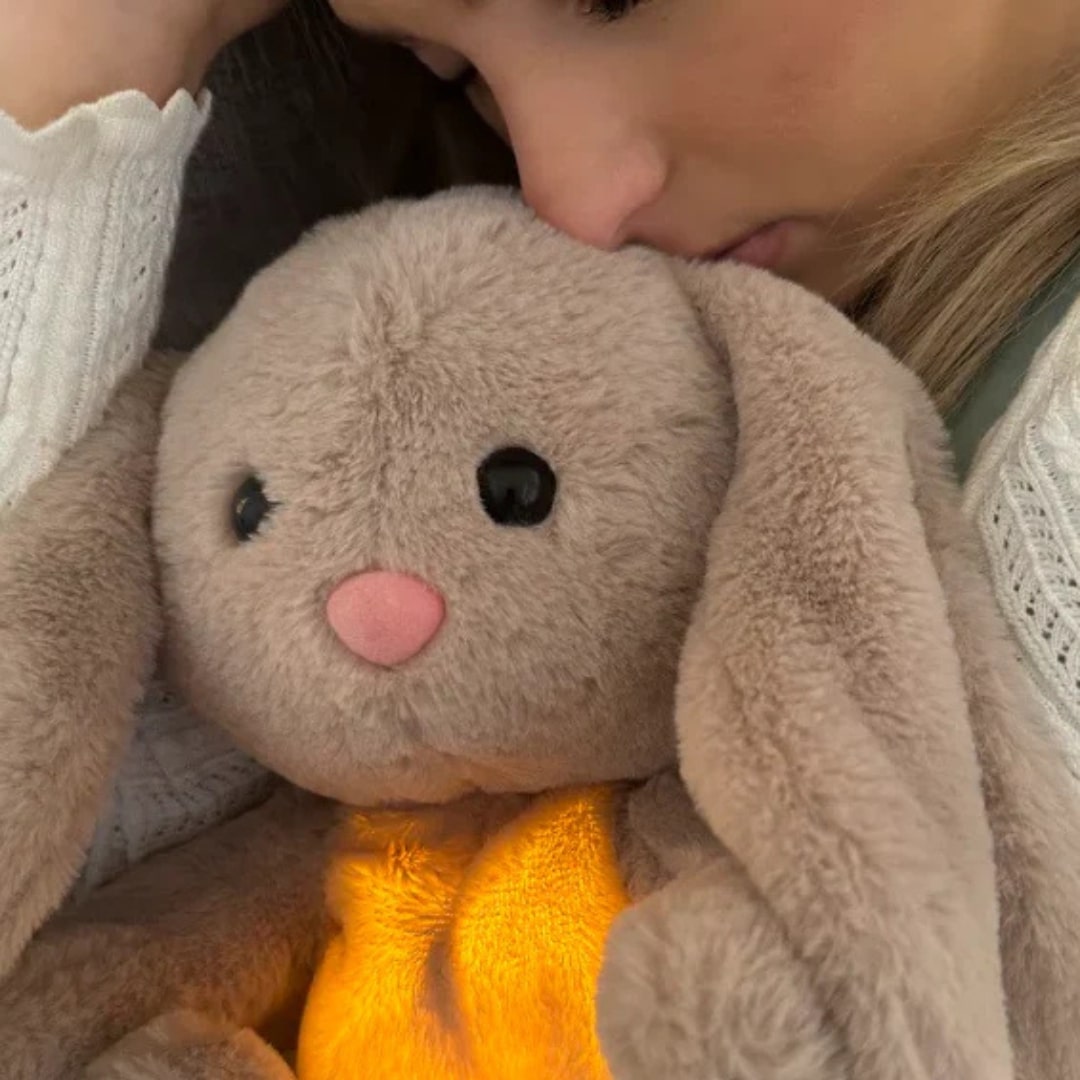 Grey rabbit stuffed animal with floppy ears and illuminated yellow belly