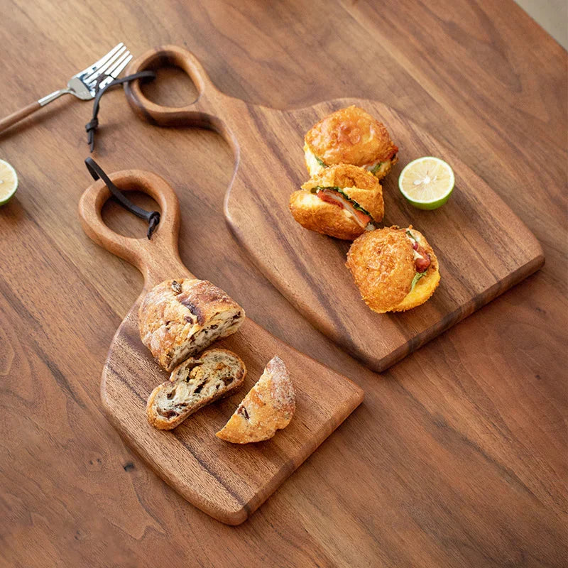 Brown walnut cutting board with shaped handle and rounded hanging hole