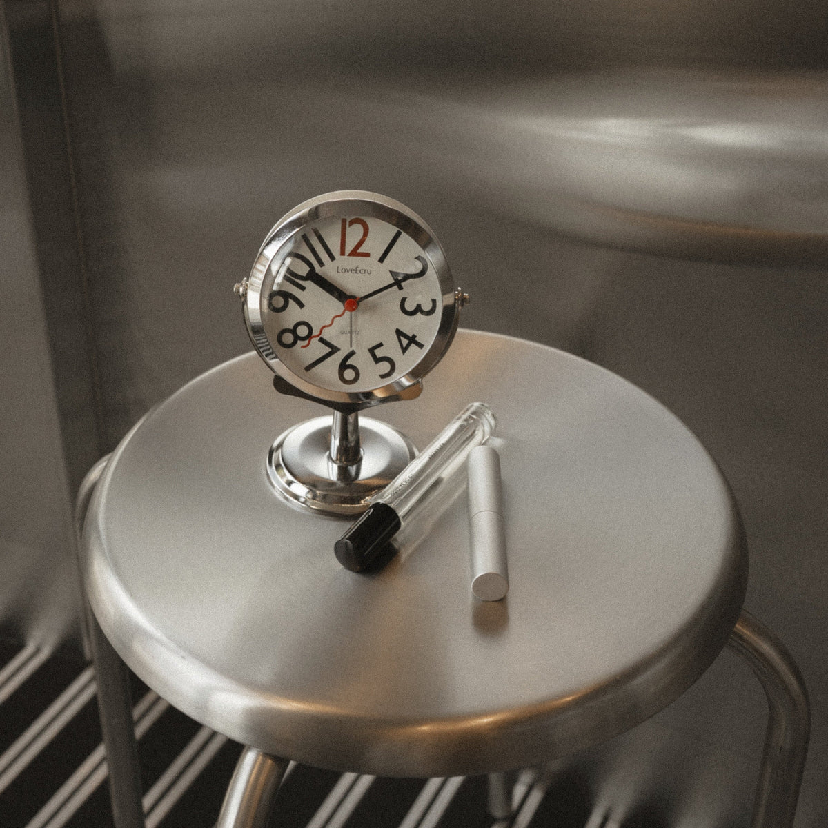 Freestanding analogue alarm clock with bold numbered dial and chrome effect stand