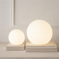 Spherical cordless LED table lamp glowing with colour-changing light