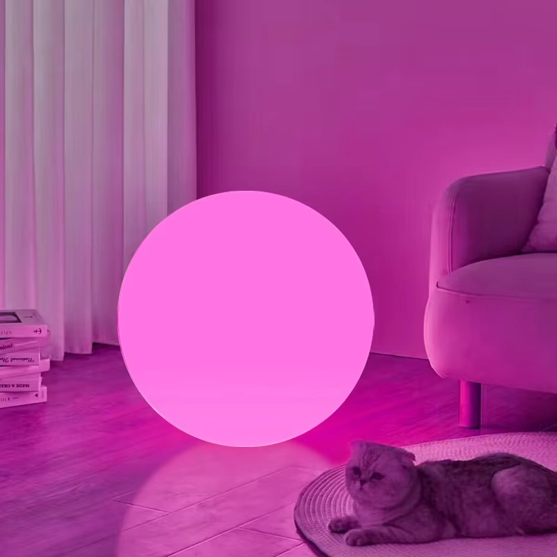 Spherical cordless LED table lamp glowing with colour-changing light