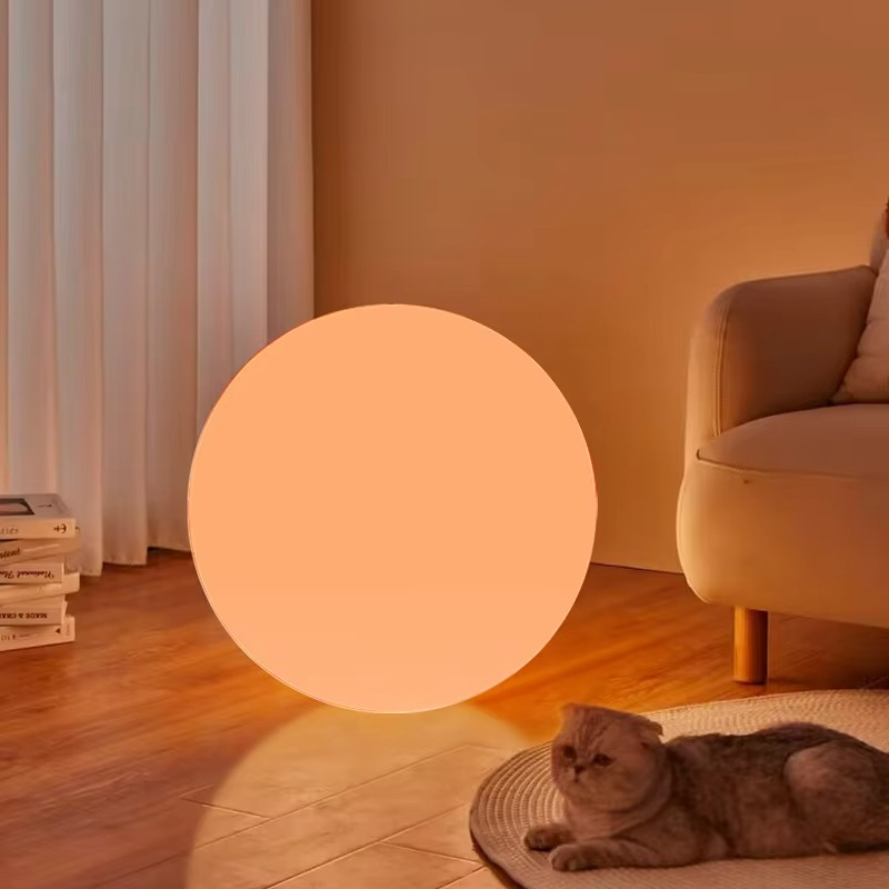 Spherical cordless LED table lamp glowing with colour-changing light