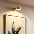 Wireless wall-mounted picture light above framed artwork with remote control