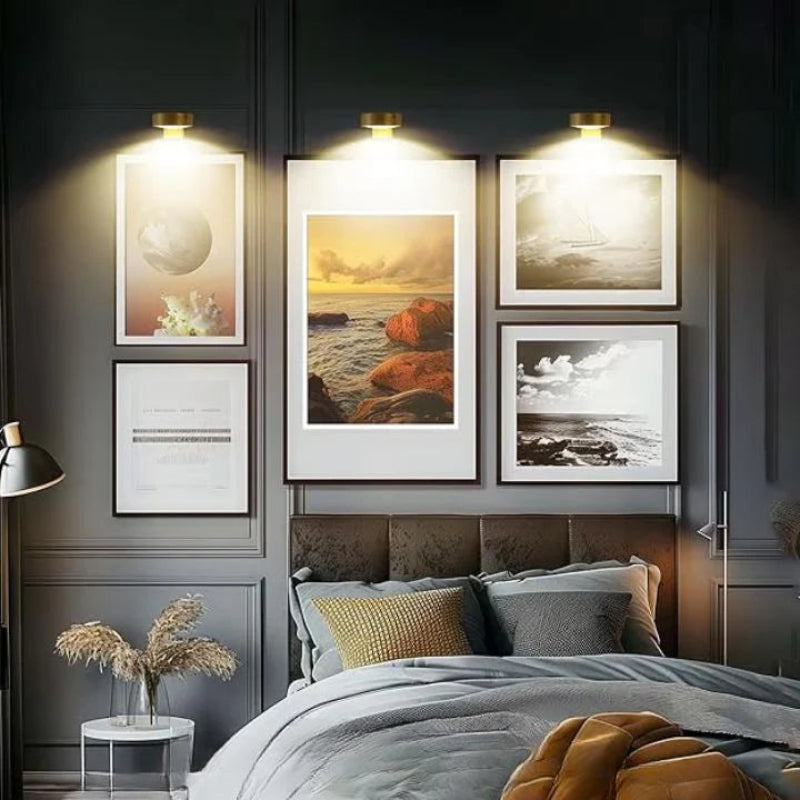 Wireless wall-mounted picture light above framed artwork with remote control