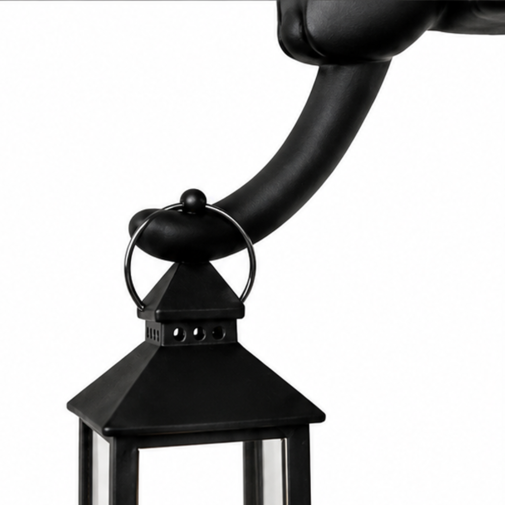 Cat figurine perched on a shelf with a hanging LED lantern