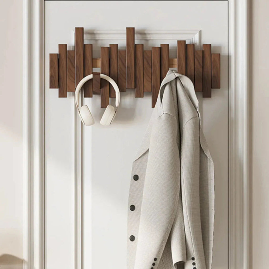 Wall-mounted slatted coat rack with folding hooks