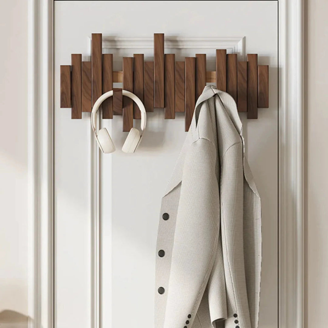 Wall-mounted slatted coat rack with folding hooks