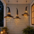Black illuminated hanging witch hat with warm lights and star strands