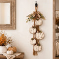 Hanging autumn garland with distressed white pumpkins, foliage and a checked bow