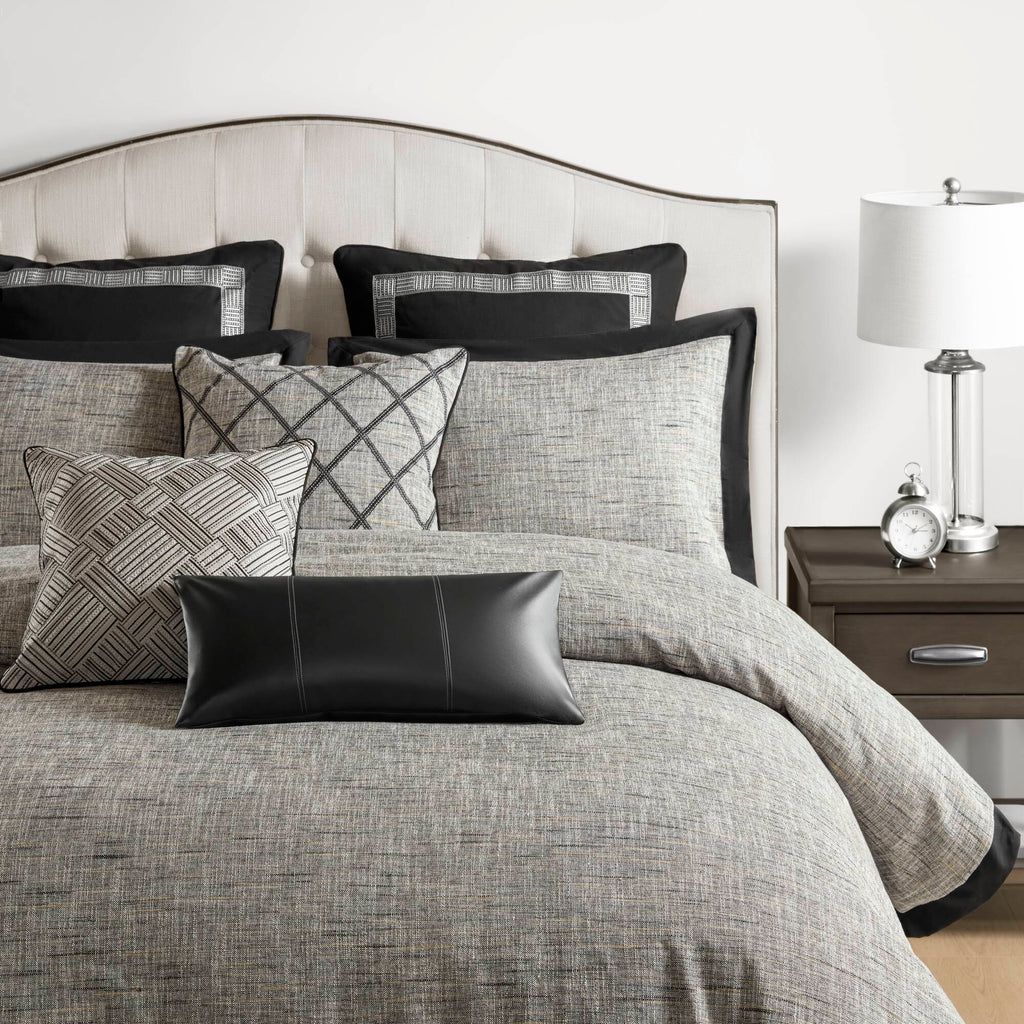 Grey textured jacquard comforter set arranged with geometric decorative pillows