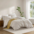 Three-piece striped duvet cover set styled on a bedroom bed
