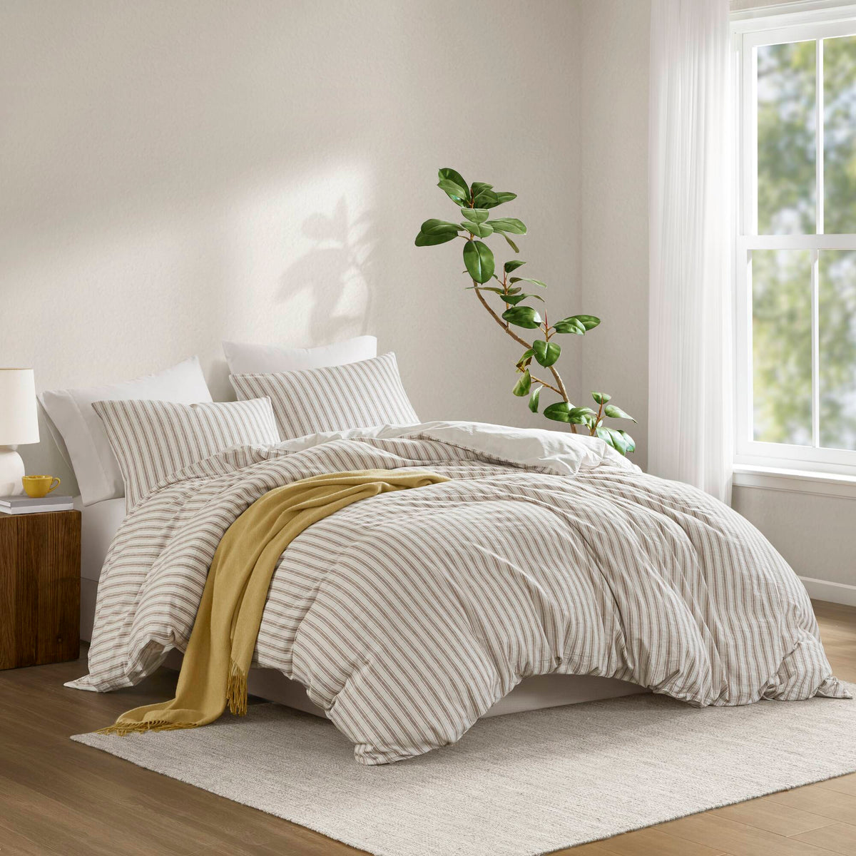 Three-piece striped duvet cover set styled on a bedroom bed