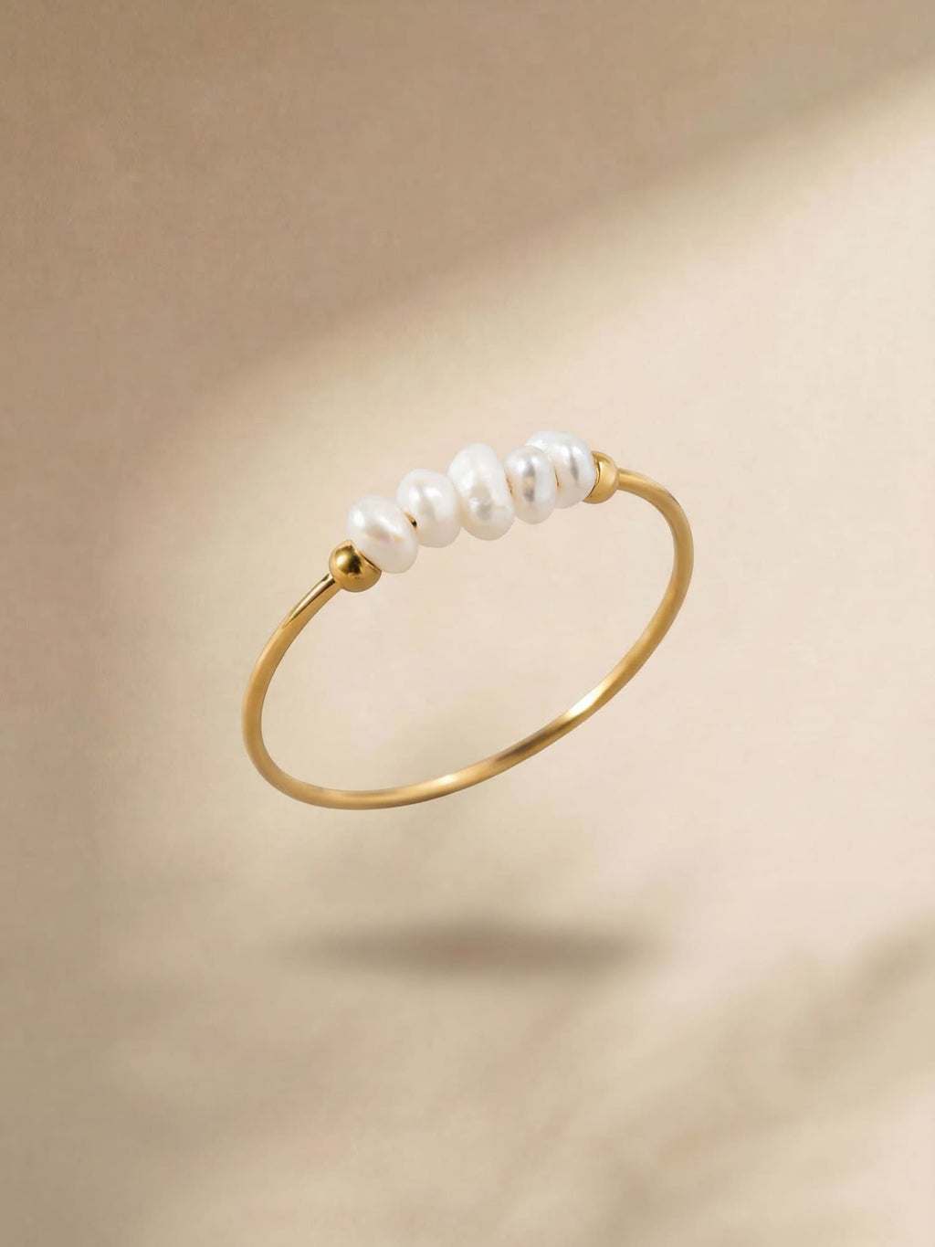 Gold-coloured pearl ring with white pearl detail