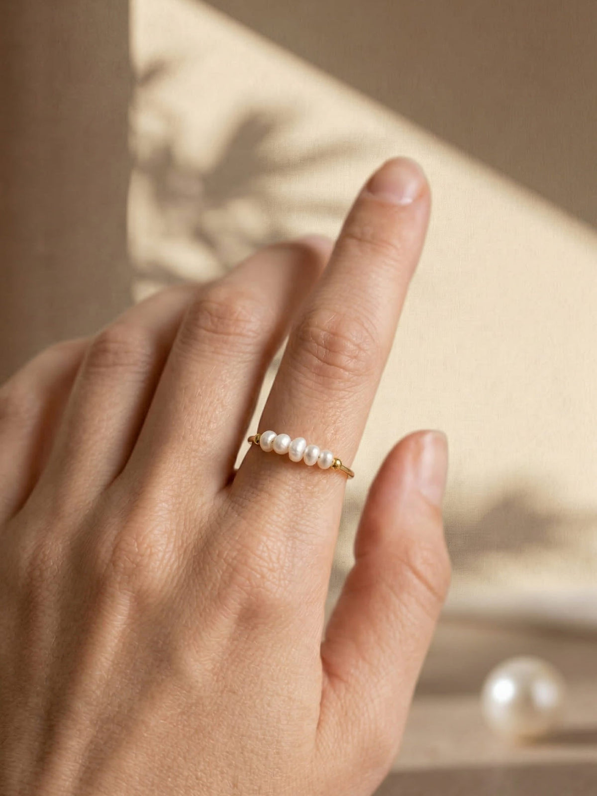 Gold-coloured pearl ring with white pearl detail