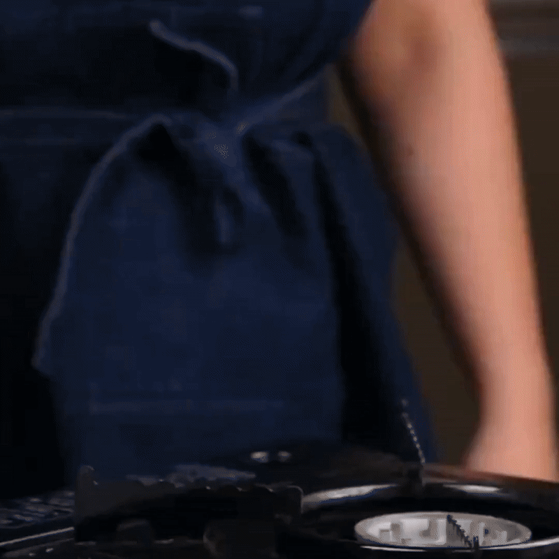 Silver uncoated titanium frying pan with long handle on a hob