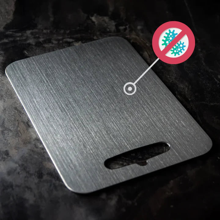 Brushed silver titanium chopping board with rounded corners and integrated handle opening