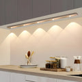 Wireless slim LED under cabinet light illuminating a kitchen worktop